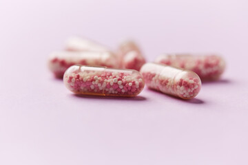 Vitamin B12 (also known as cobalamin) capsules on bright paper background. Soft focus. Close up. Copy space.	