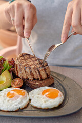 A Deliciously Cooked Steak Served with Fried Eggs and Fresh Salads Highlighting a Perfectly...