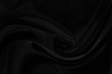 Black gray satin dark fabric texture luxurious shiny that is abstract silk cloth background with patterns soft waves blur beautiful.