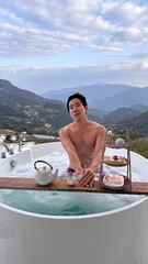 Handsome Man Enjoying Luxury Bubble Bath on Veranda with Breathtaking Mountain Valley View