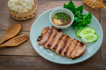 Grilled pork neck and thai spicy dipping sauce on plate served with sticky rice