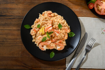 Delicious Shrimp Risotto with Fresh Basil on a Black Plate