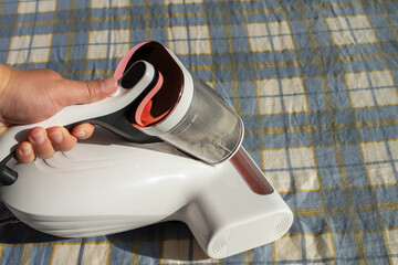 man operating a mite remover on a bed