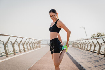 Young strong sporty sportswoman female runner jogger in sport clothes warm up training do stretch...