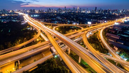 Complex Highway Interchange at Night with Cityscape Silhouette in the Distance