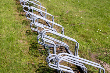 Empty bicycle racks standing on green grass field