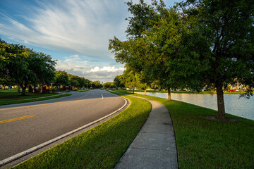 Curved Road and Sidewalk Beside a Lake on a Sunny Day