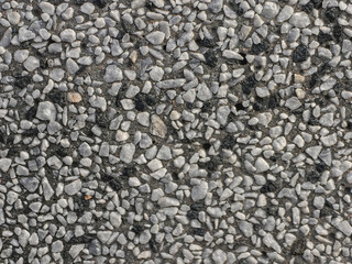 Detailed view showcasing a textured surface composed of various sized pebbles embedded in concrete.
