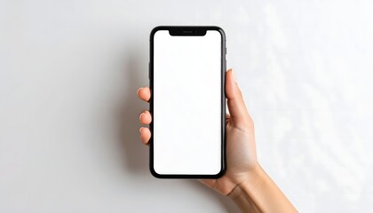 Woman's hand holding a modern smartphone with a blank white screen for mockup on a gray background
