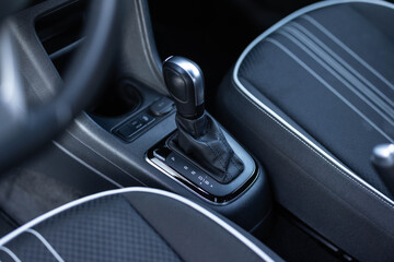 Obraz premium Handle of electric car gearbox control. Design details of minimalist concept of electric car - close-up details of automatic transmission and gear stick. Automatic gear lever and gear shift