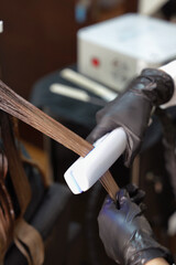 Close-up of a professional cryotherapy hair treatment using a special device in a beauty salon. A...