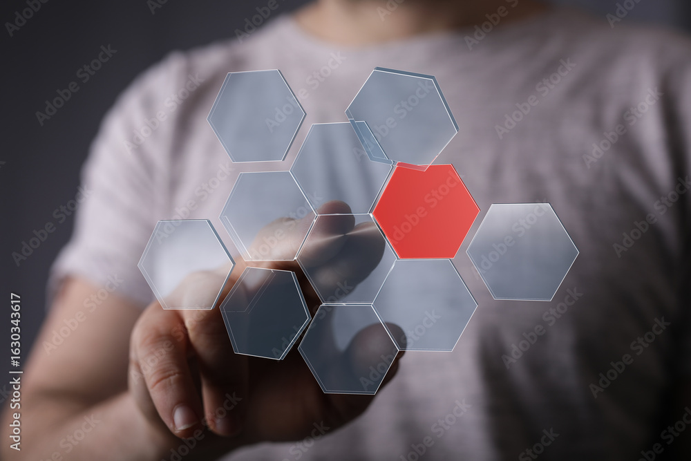 Poster person touches a digital hexagon network interface,one hexagon is highlighted in red.