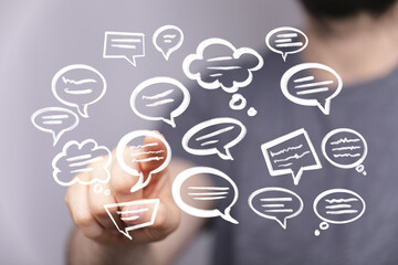 Hand interacting with floating speech bubbles, representing communication, social media, or online...