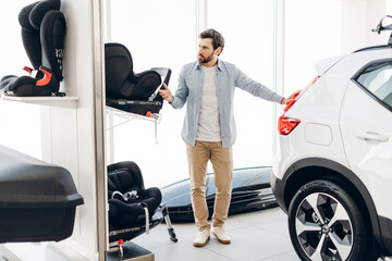 Father choosing child car seat in a store