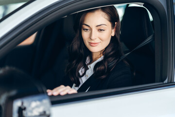 Businesswoman driving modern car wearing seatbelt