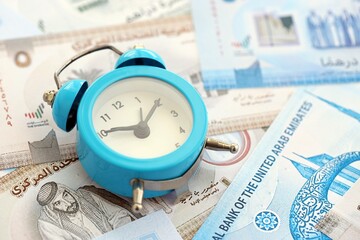 United Arab Emirates dirham currency money bills and alarm clock. The concept of time management...