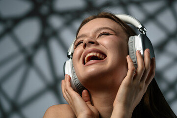 Joyful Young Adult Listening to Music on Headphones and Smiling