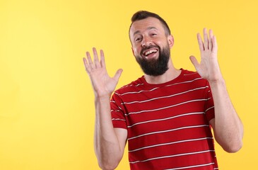 Handsome man laughing on yellow background. Positive emotion