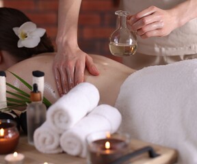 Woman receiving back massage with oil in spa salon, closeup