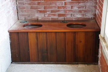 A vintage wooden toilet with its simple design reflecting a bygone era.