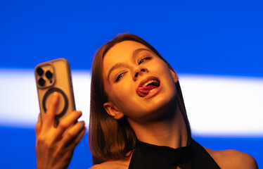 Young Woman Taking a Fun Selfie with a Smartphone