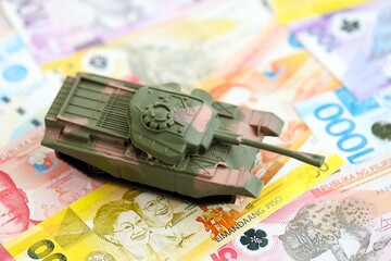 Philippines peso currency money bills and toy tank. The concept of army funds and weapons sales