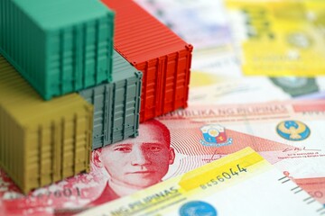 Philippines peso currency money bills and toy cargo containers. The concept of shipping and...