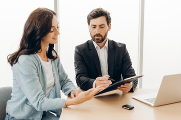 Financial advisor showing contract to client in office meeting