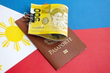 Philippines peso currency money bills and passport lies on flag. The concept of travel and vacation