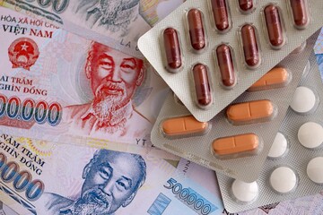 Vietnamese dong currency money bills and medicine pills. The concept of medicine and pharmacy
