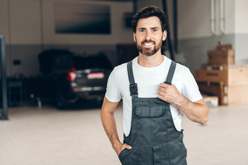 Portrait of confident mechanic smiling in auto repair shop