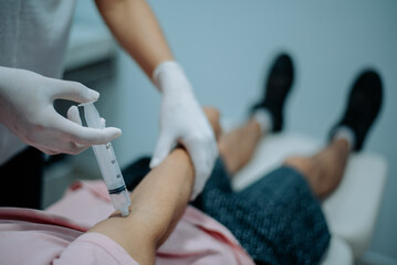Close-up of nurse preparing a patient’s arm for a blood draw in a medical examination room.