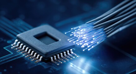 Close-up of fiber optic cables connected to a circuit board.  Blue glowing optical fibers near a chip.  High-tech components