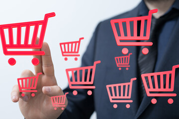 A businessman interacts with digital shopping carts, representing online sales and e-commerce.