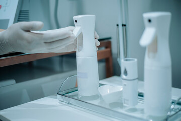 Skincare products and cotton pads on glass tray in a clean aesthetic space, ready for facial...