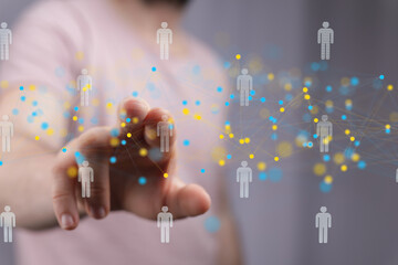 Hand interacting with a digital network of people, representing global communication and connection.