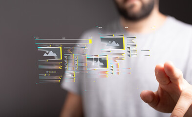 A man interacts with a transparent digital screen showing website design elements. Modern technology concept.