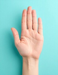 Hand palm up against teal background