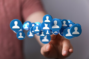 Hand interacting with digital profile icons, representing social media networking and connections.