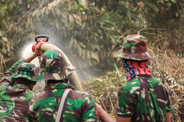 Indonesian soldiers fight intense land fires in Kalimantan using high-pressure hoses, battling...