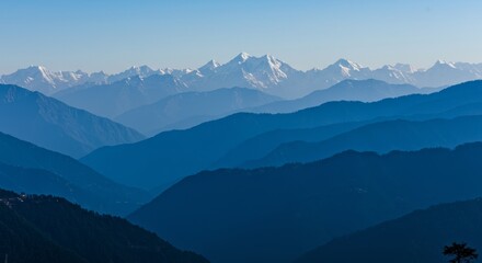 Fototapeta premium Nature wallpaper. Layered Mountain Range Landscape with Snow-capped Peaks in Clear Sky