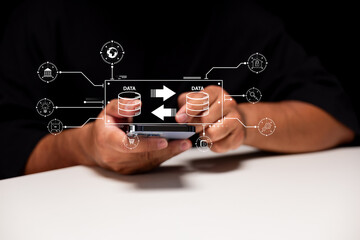A person interacts with a smartphone displaying data transfer icons, symbolizing digital communication and information exchange.