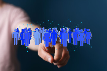 Image depicts a hand interacting with a digital network of diverse people, symbolizing global...