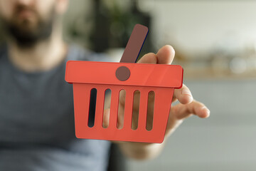 Person holding a digital shopping cart icon.  E-commerce, online retail, purchase.
