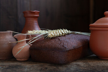 Homemade rye bread and vintage ceramic kitchenware on an old wooden table.