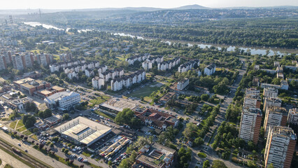 Drone view from a tall building in New Belgrade, Serbia, showing rows of residential blocks glowing...