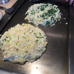 Two Uncooked Japanese Okonomiyaki Pancakes on a Teppanyaki Pan