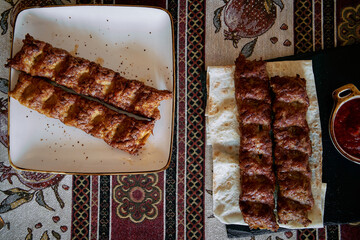 Deliciously Crafted Meat Rolls Served on a Decorative Table with a Side of Flavorful Sauce, Perfect for Indulging in Tasty Culinary Delights.
