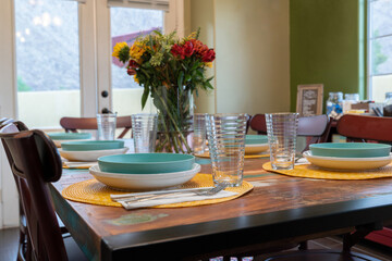 Close-up of a set dining table with bowls, plates, glasses, and silverware