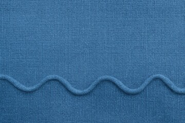 A close-up of a textured blue fabric with a subtle wavy pattern, evoking a sense of softness and comfort